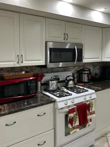 a kitchen with stainless steel appliances granite countertop a stove a microwave and cabinets