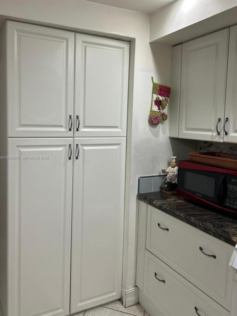 7100 Southwest 112th Place Miami, FL 33173 - Photo 10 of 21 a room with white cabinets and a wooden floor