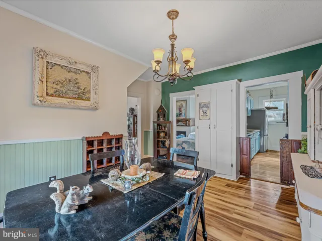 a view of a dining room with furniture a chandelier and wooden floor