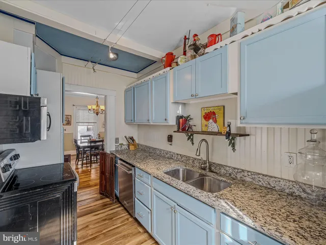 a kitchen with stainless steel appliances granite countertop a sink a stove and cabinets