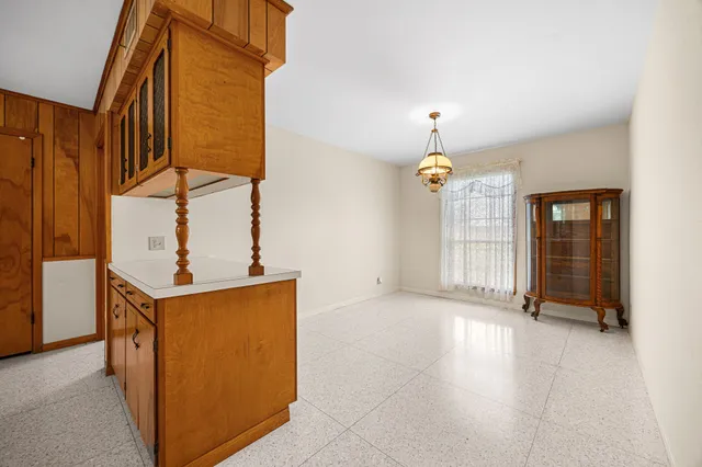 a kitchen with stainless steel appliances granite countertop a kitchen island a stove a table and chairs in it