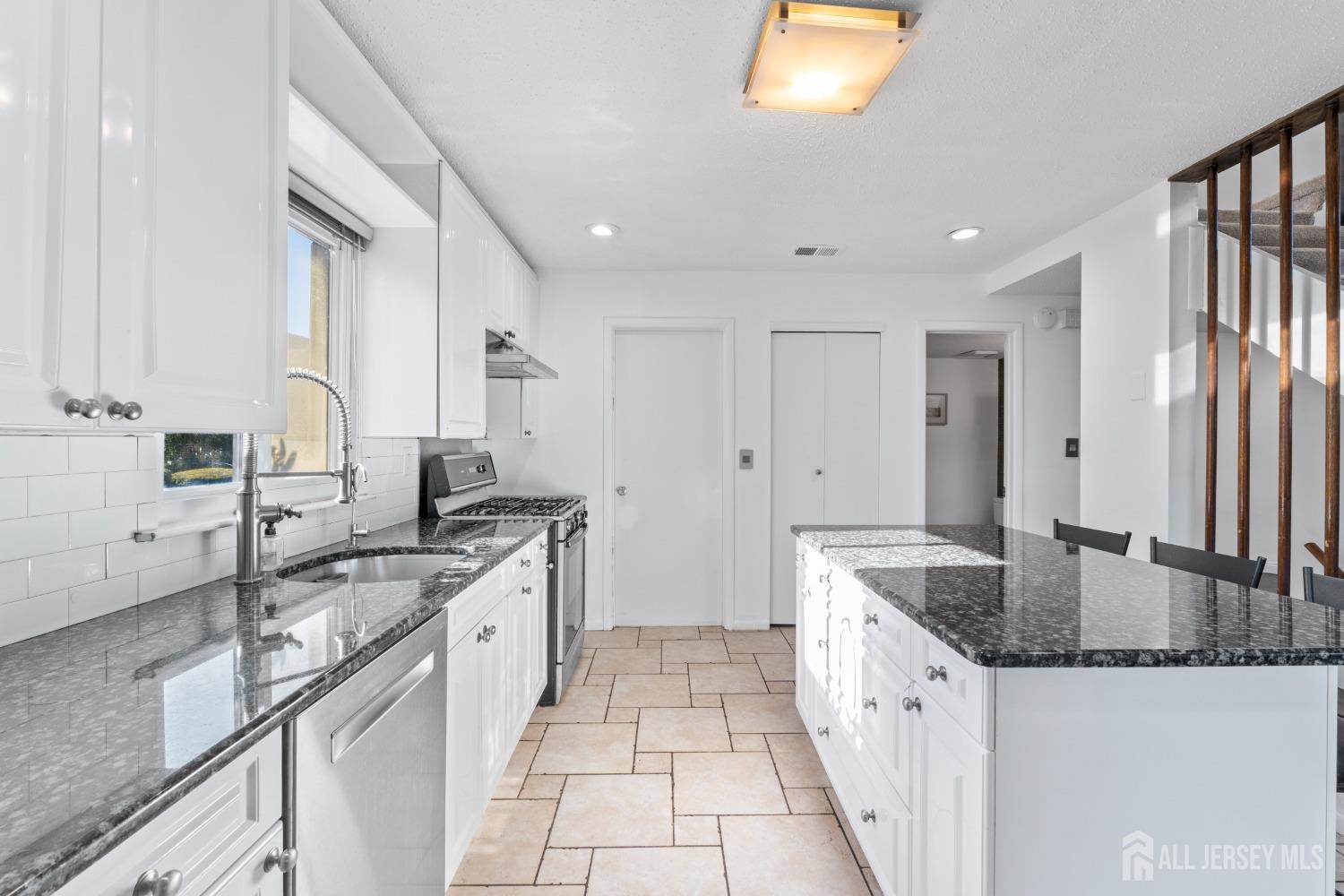 171 Westgate Drive Edison, NJ 08820 - Photo 20 of 49 a large kitchen with granite countertop a sink stove and cabinets