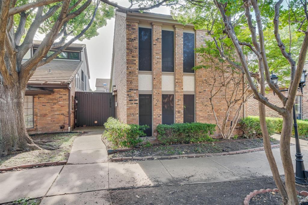 a view of a brick house with a large windows and large tree