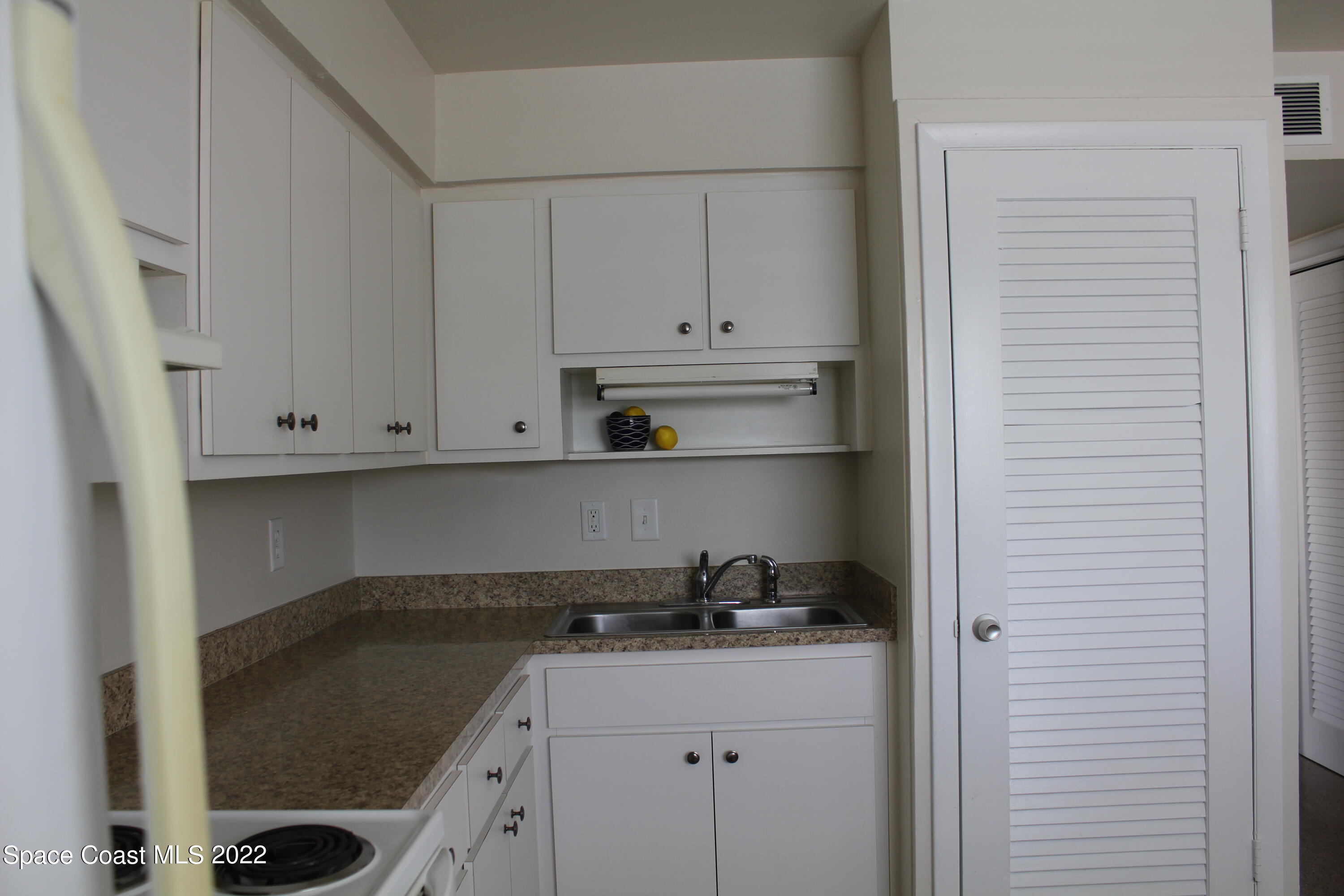 651 Palm Drive, Unit C2 Satellite Beach, FL 32937 - Photo 11 of 13 a kitchen with stainless steel appliances granite countertop a sink stove and cabinets