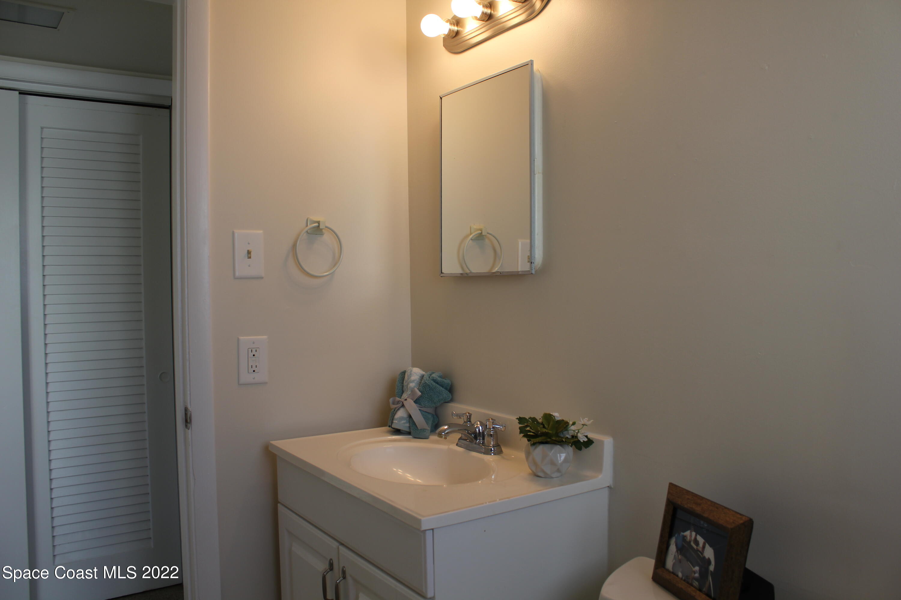 651 Palm Drive, Unit C2 Satellite Beach, FL 32937 - Photo 7 of 13 a bathroom with a sink toilet and a mirror