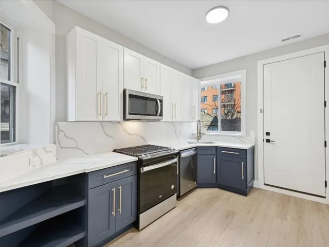a kitchen with stainless steel appliances granite countertop a sink stove and microwave