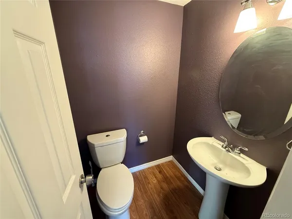 a bathroom with a toilet a sink and mirror