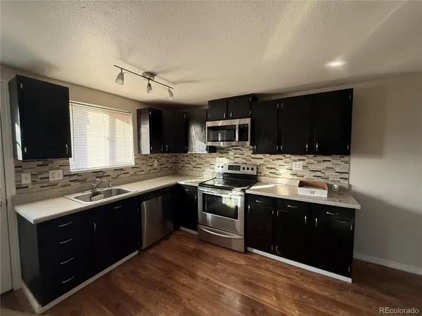 a kitchen with stainless steel appliances kitchen island granite countertop a stove top oven sink and cabinets