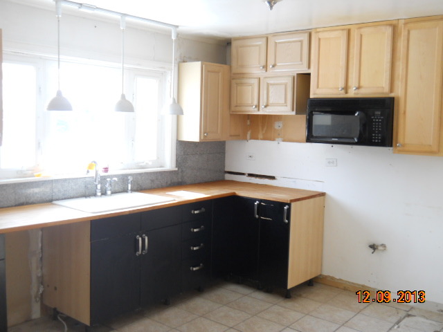 6 Butterfield Road Lake Zurich, IL 60047 - Photo 7 of 11 a kitchen with stainless steel appliances granite countertop a sink and a microwave