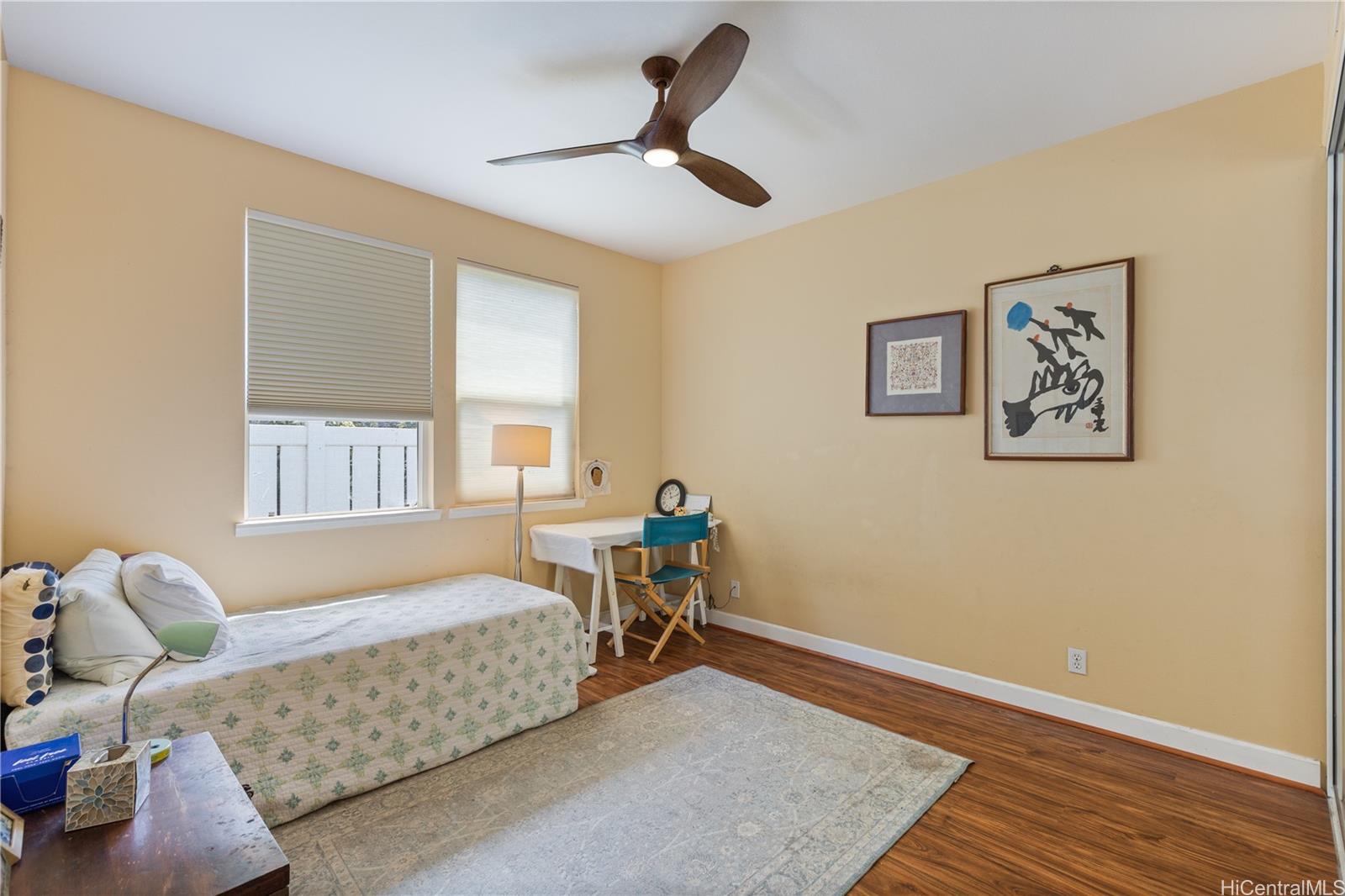 92-1015 Koio Drive, Unit S52 Kapolei, HI 96707 - Photo 14 of 18 a bedroom with a bed and wooden floor