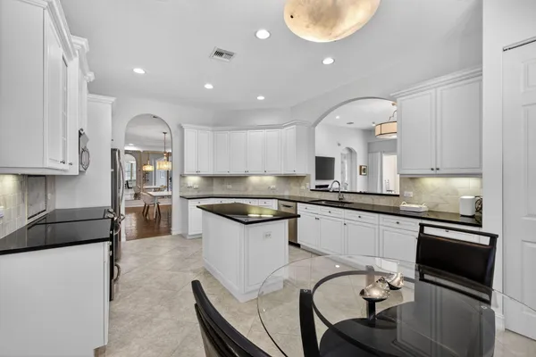 a kitchen with stainless steel appliances granite countertop a sink a stove and a refrigerator