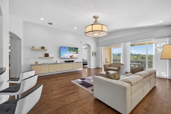 a living room with furniture wooden floor and a large window