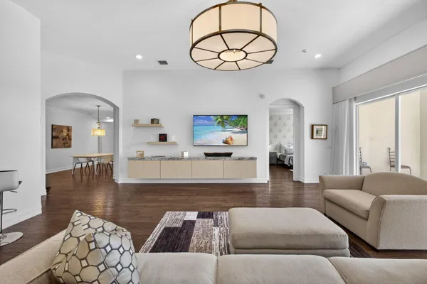 a living room with furniture a dining table and a chandelier