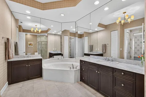 a large bathroom with a double vanity sink mirror and a bathtub