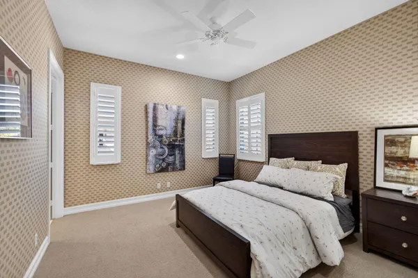 a bedroom with a large bed and a ceiling fan