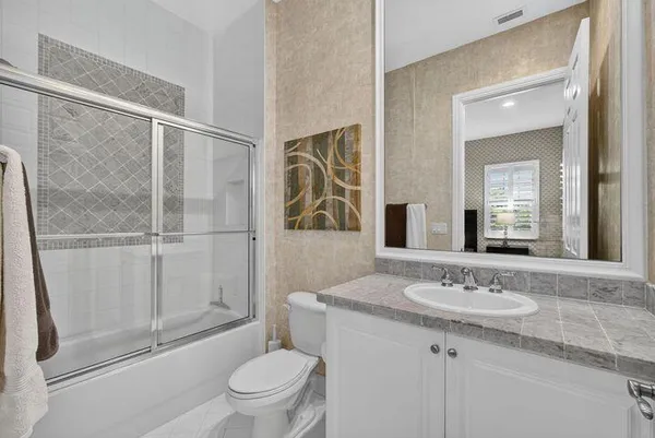 a bathroom with a granite countertop sink toilet and shower