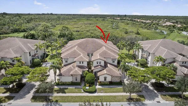 an aerial view of residential houses with outdoor space and trees