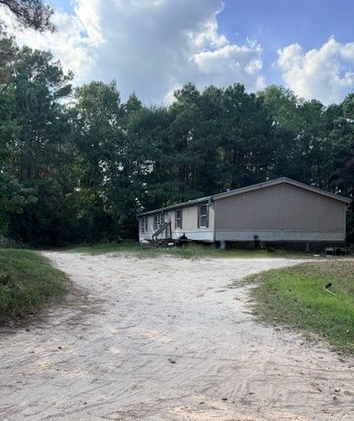 1705 Spring Ridge Road Coldspring, TX 77331 - Photo 1 of 26 a backyard of a house with lots of green space and lake view