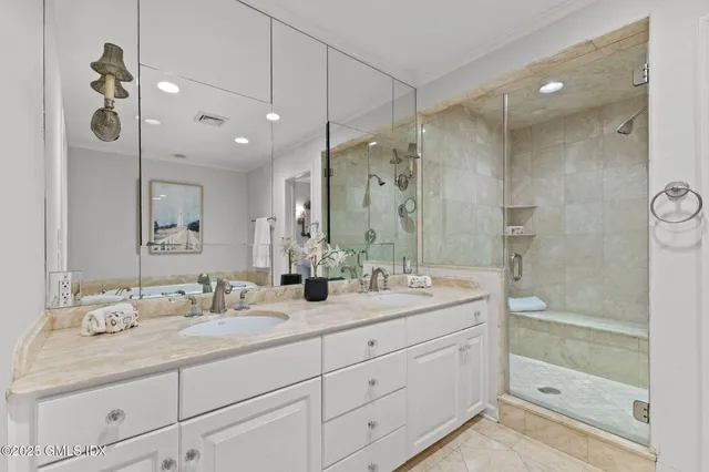 a bathroom with a granite countertop sink mirror and shower