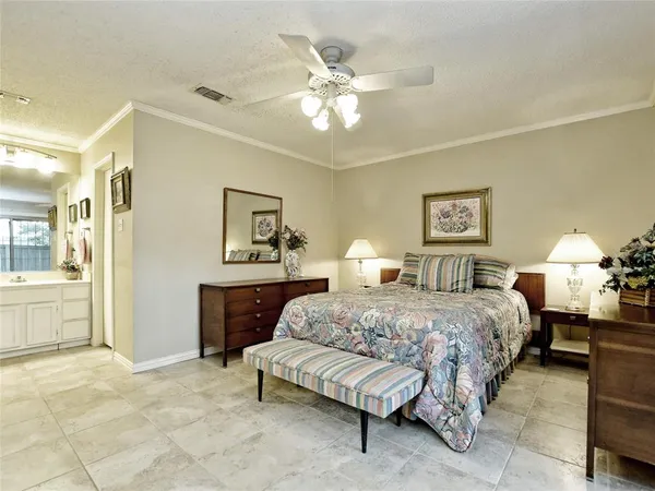 a bedroom with a large bed and a chandelier