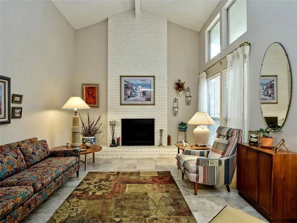 a living room with furniture fireplace and a large window