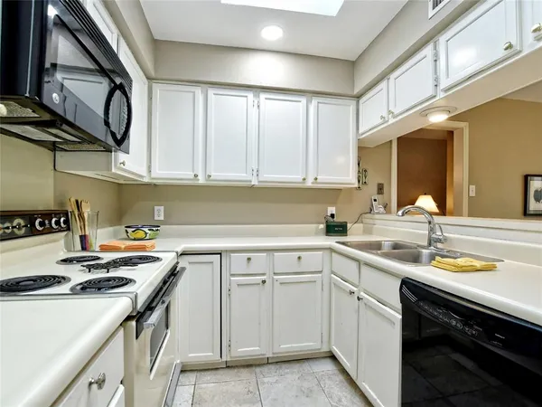 a kitchen with a sink stove top oven and cabinets