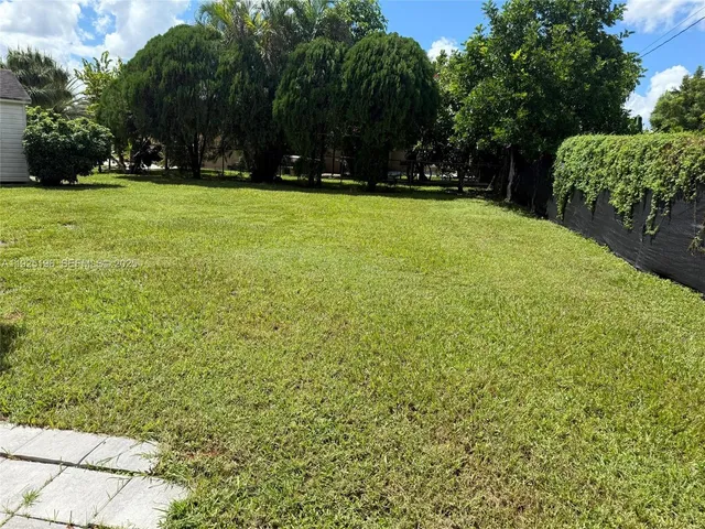 a view of a backyard with plants and a garage