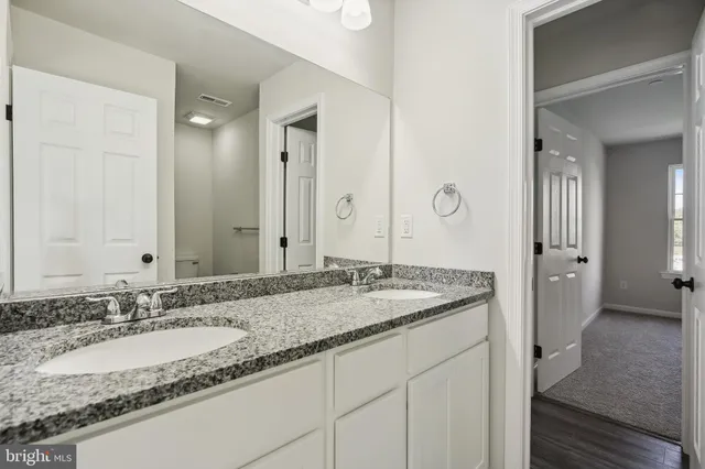 a bathroom with a granite countertop sink and a mirror