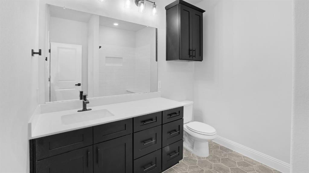 1608 Keneipp Road Carrollton, TX 75006 - Photo 12 of 13 a bathroom with a toilet a sink and mirror