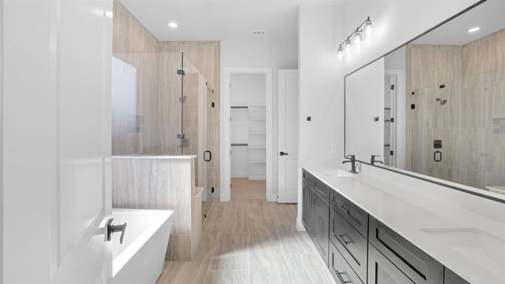 1608 Keneipp Road Carrollton, TX 75006 - Photo 8 of 13 a large bathroom with a tub a sink and mirrors