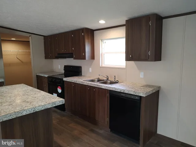 a kitchen with a sink a stove a refrigerator and cabinets