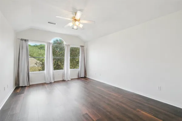 a view of an empty room with wooden floor