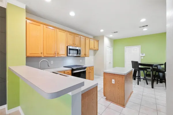 a kitchen with stainless steel appliances a stove a sink and a microwave