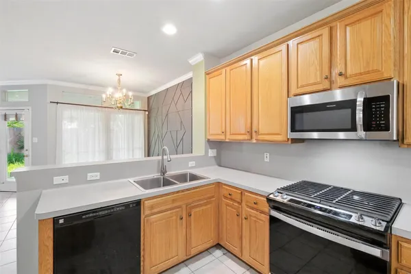 a kitchen with a stove a sink a microwave and a refrigerator