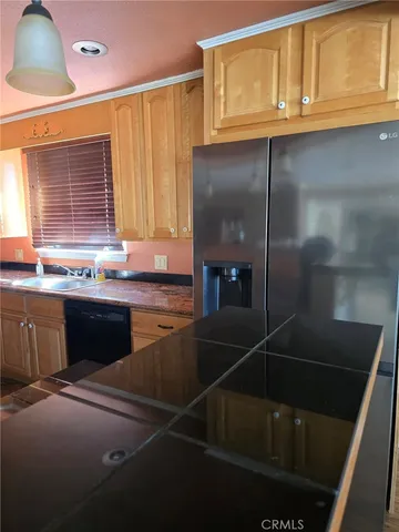 a kitchen with a sink a refrigerator and cabinets