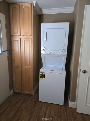 a utility room with wooden floor washer and dryer