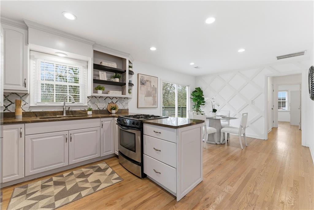 2975 Nursery Road Southeast Smyrna, GA 30082 - Photo 6 of 36 a kitchen with stainless steel appliances kitchen island granite countertop a stove a sink and a microwave