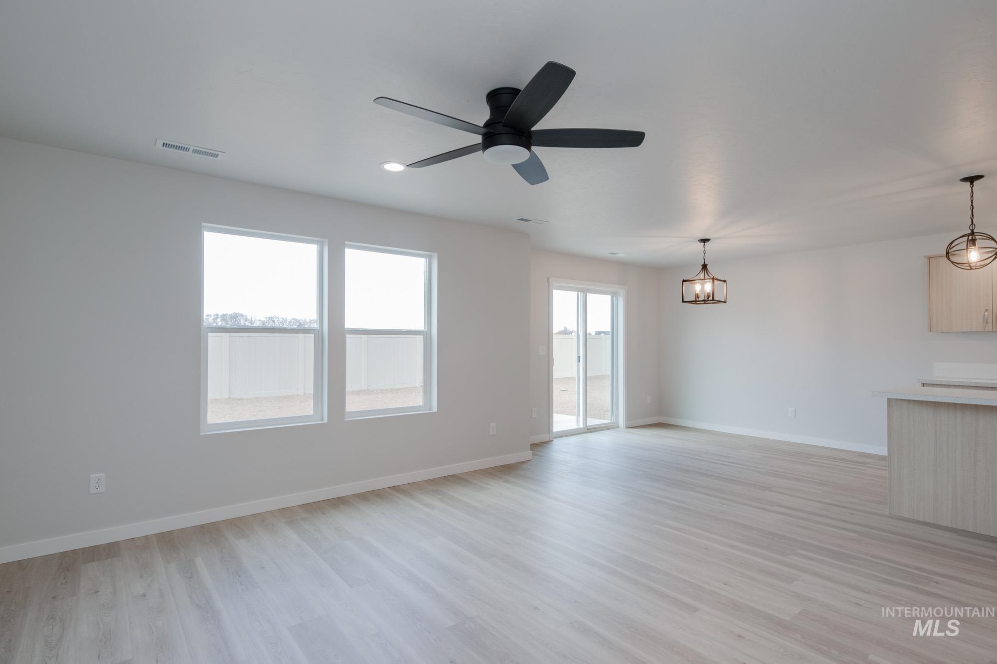 3089 South Maple Rnch Way Nampa, ID 83686 - Photo 9 of 22 Unfurnished living room featuring light wood-style floors, a ceiling fan, and recessed lighting