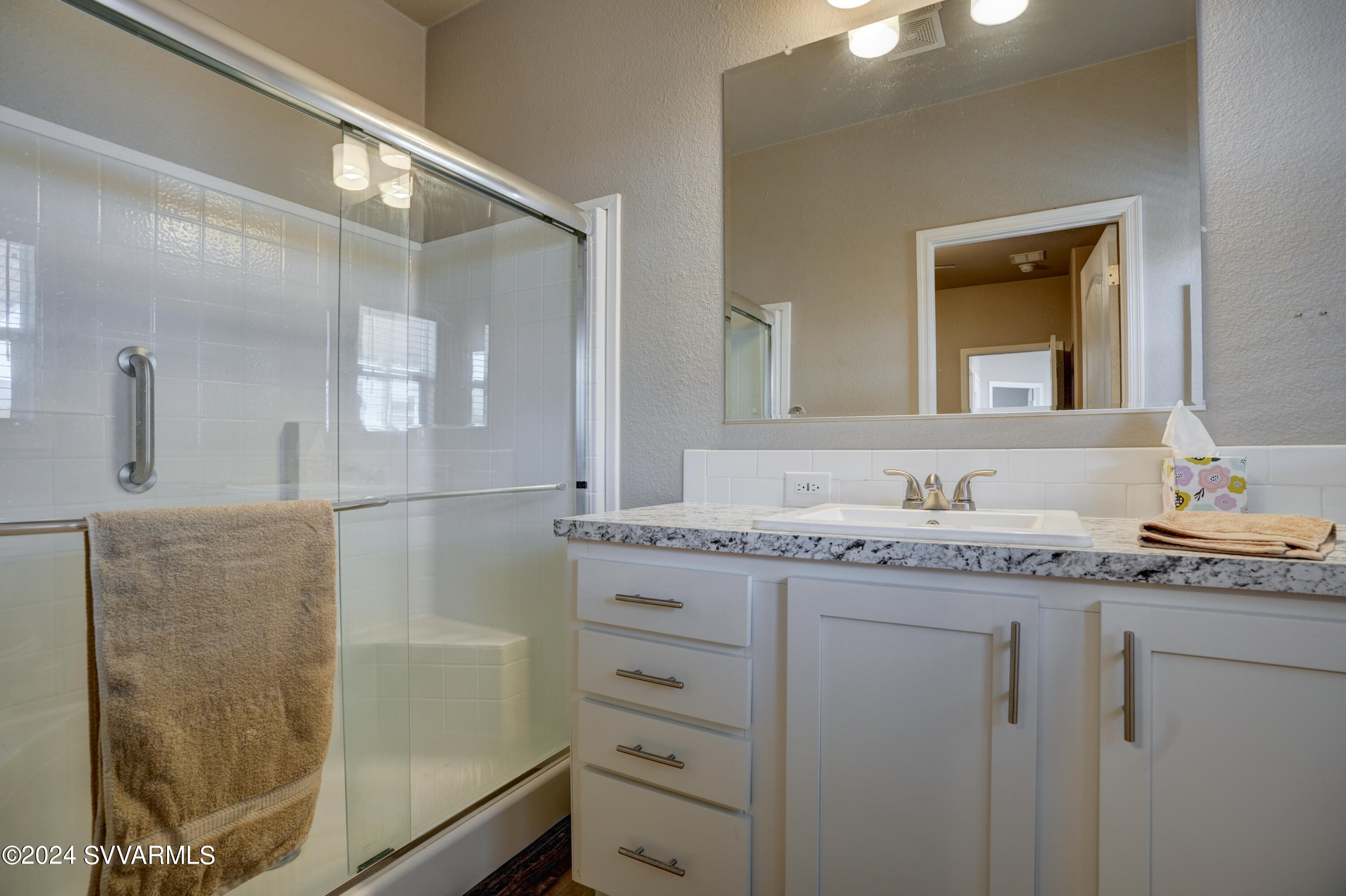 999 Thorton Road, Unit 21 Camp Verde, AZ 86322 - Photo 14 of 23 a bathroom with a granite countertop sink mirror and a shower
