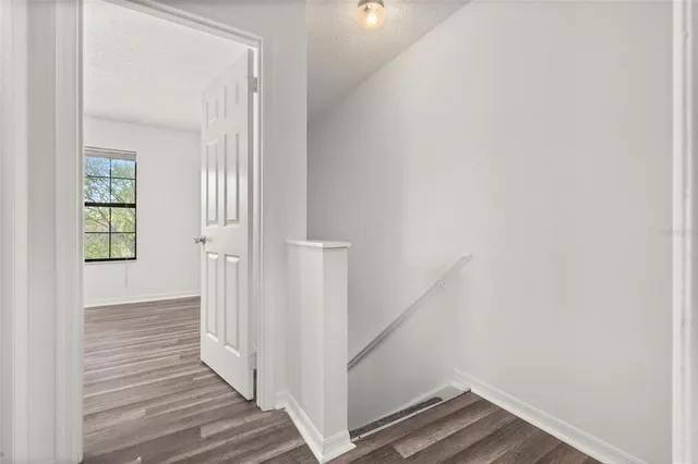a view of a hallway with wooden floor and entryway