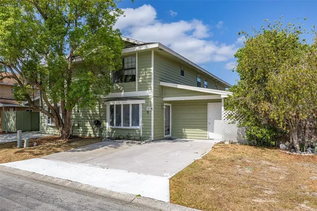 a front view of a house with a yard and potted plants