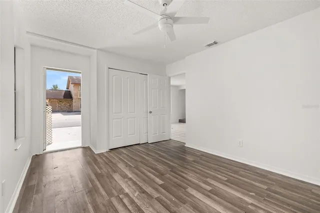 a view of a room with wooden floor and a floor to ceiling window