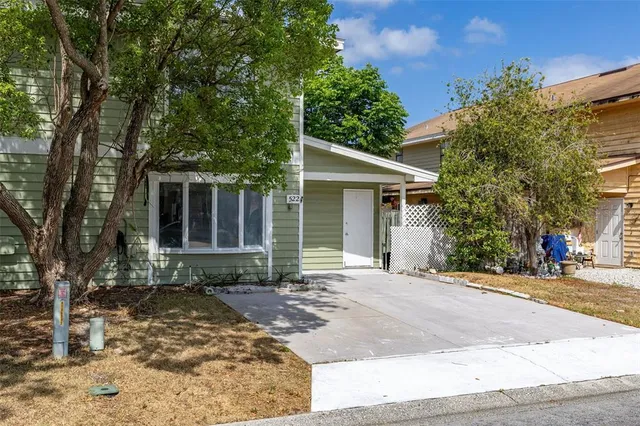 a front view of a house with a yard and potted plants
