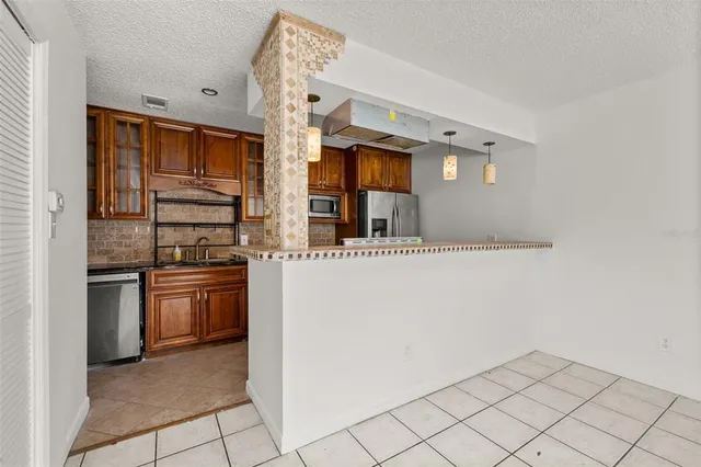 a kitchen with stainless steel appliances granite countertop a refrigerator and a stove top oven