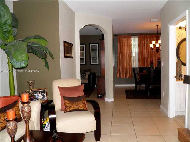 9237 Southwest 227th Street, Unit 12 Cutler Bay, FL 33190 - Photo 3 of 9 a living room with furniture and a flat screen tv