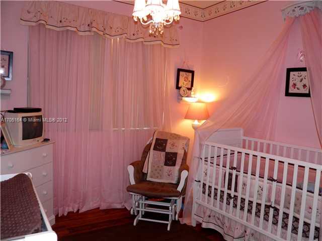 9237 Southwest 227th Street, Unit 12 Cutler Bay, FL 33190 - Photo 6 of 9 a bedroom with a bed and a chair