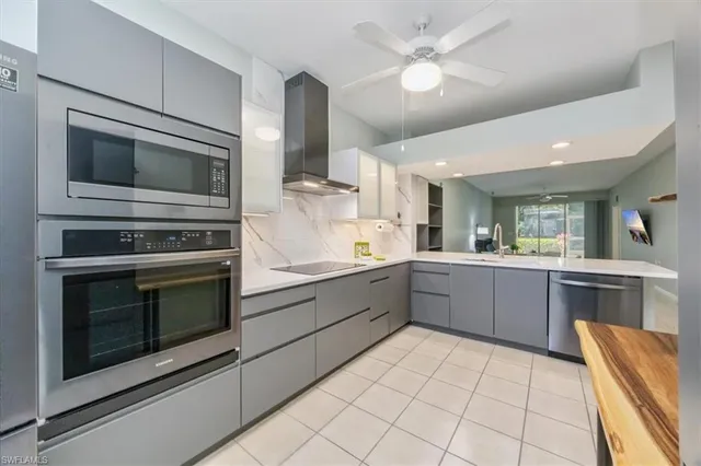 a kitchen with stainless steel appliances kitchen island granite countertop a stove top oven microwave and cabinets