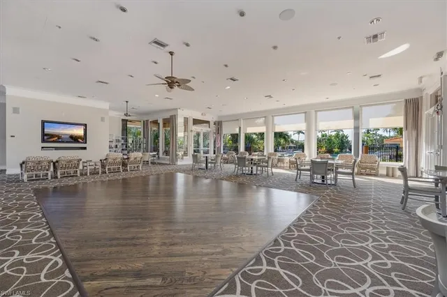 a very nice looking living room with a large window a couch and chandelier