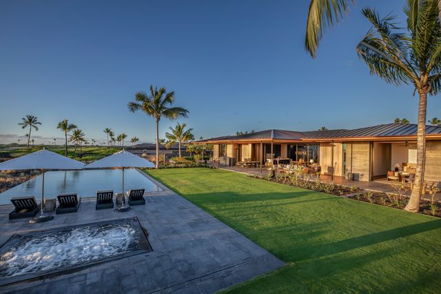 a view of a house with backyard and sitting area