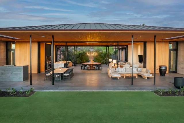 a living room with patio furniture and a garden